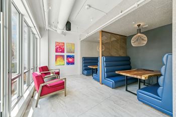 A living room with blue couches and chairs and a wooden table